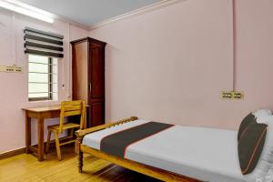 a bedroom with a bed and a desk and a table at Collection O Mali Residency in Pullappalli
