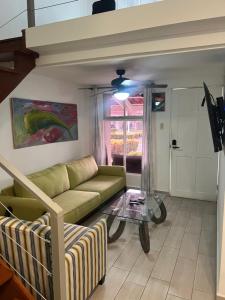 un soggiorno con un divano e un tavolo di vetro di Enchanting 3 BR 2 Bath Condo in the Heart of Jaco a Jacó