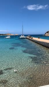 a beach with boats in the water next to a beach at Da Marta Appartamento VISTA MARE MOZZAFIATO ISOLA ROSSA in Cascabraga