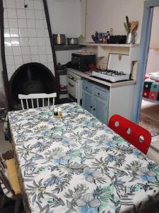 a kitchen with a table with a flower pattern on it at Pedregulho Experience in Caldeirinhas