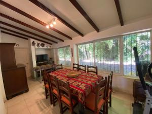 a dining room with a table and chairs and windows at Casa RINCON DEL SOL in Villa la Bolsa