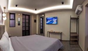 a bedroom with a bed and a tv on the wall at Hotel Capitalino in Pachuca de Soto
