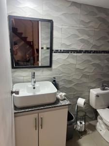 un bagno con lavandino, water e specchio di Enchanting 3 BR 2 Bath Condo in the Heart of Jaco a Jacó
