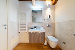 a bathroom with a sink and a toilet and a mirror at Suite Deluxe in Palazzo Storico - Centro Sassari - Appartamento Alghero in Sassari +33 photos