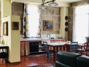 a kitchen with a table and chairs in a room at Casa Bella para peregrinos- Charm House for pilgrims in A Guarda