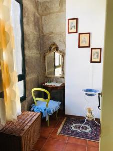 a hallway with a yellow chair and a mirror at Casa Bella para peregrinos- Charm House for pilgrims in A Guarda