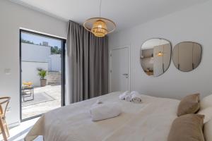 a white bedroom with a large bed and two mirrors at Cocco e Limone in Sutivan