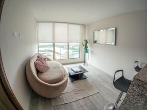 a living room with a chair and a table at Santorini Apartamentos Amoblados in Pereira