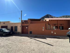 a building with a car parked in front of it at Posada Tierra Adentro 2 in Purmamarca