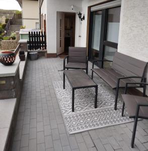 a patio with chairs and a bench and a table at Ferienwohnung Zur goldenen Glocke in Mechernich