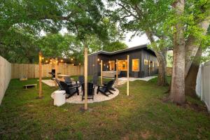 a backyard with a black house with a tree at New-Dog Friendly,Hot Tub, Fire-pit, 1 mile to DTWN in Saint Augustine