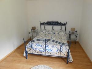 ein Schlafzimmer mit einem blauen und weißen Bett mit zwei Tischen in der Unterkunft Domaine Harrieta in Saint-Jean-le-Vieux
