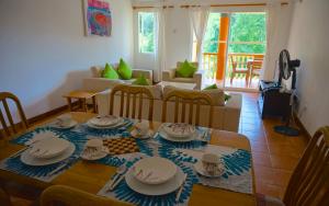 a living room with a table with dishes on it at La Villa Therese in Anse Royale