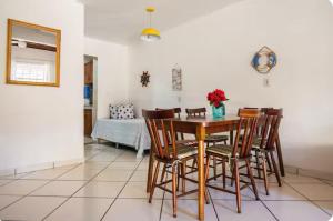 VIVA BUZIOS no Condominio Aqua Marina casa13 في بوزيوس: غرفة طعام مع طاولة وكراسي خشبية