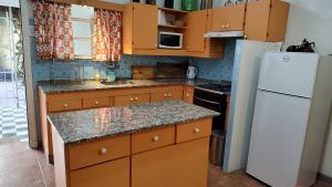 eine Küche mit Holzschränken und einem weißen Kühlschrank in der Unterkunft Amplia casa cerca del centro de la ciudad in Cordoba + 15 Fotos