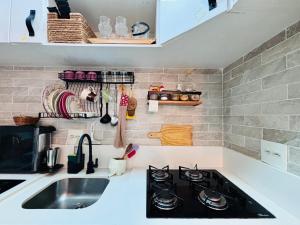a kitchen with a stove and a sink at Ap completo com ar e garagem coberta próximo ao metrô in Brasilia