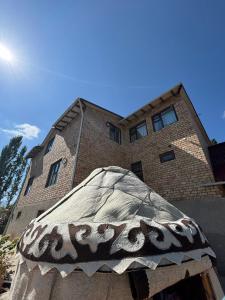 a building with a covering in front of it at Guest House Ayara in Kyzyl-Tuu