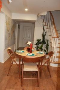 a dining room table with chairs and a staircase at Serene Don River Nature gateway- 2BR suite, Private Patio, Free Parking in Toronto