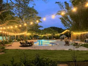 a backyard with a pool at night with lights at Hotel Amigo Nicaragua in Nindirí