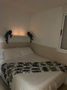 une chambre avec un lit avec une couette noire et blanche dans l'établissement Playa sol y arena, à Valence 4 autres photos