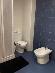 une salle de bain carrelée bleue avec toilettes et bidet dans l'établissement Playa sol y arena, à Valence
