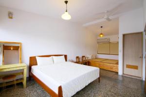 - une chambre avec un lit blanc, un bureau et une sidx dans l'établissement Little Time Guesthouse, à Taïtung 5 autres photos