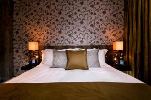 a bedroom with a large bed with two lamps at The Hide London in Hendon