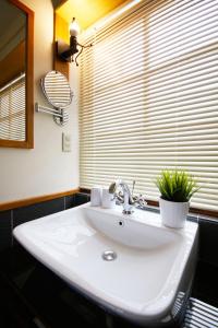 La salle de bains est pourvue d'un lavabo blanc et d'une fenêtre. dans l'établissement Little Time Guesthouse, à Taïtung