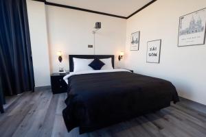 a bedroom with a large bed with a black blanket at Atlantis Apartment Nguyen Thai Hoc in Hanoi +18 photos
