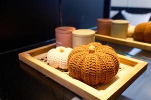 two knitted pumpkins in a wooden tray on a table at Atlantis Apartment Nguyen Thai Hoc in Hanoi