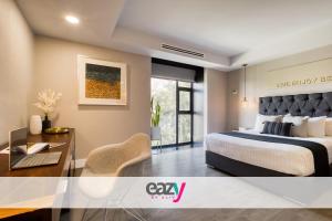 a bedroom with a king sized bed and a desk at Eazy Rio by ULIV in Tijuana