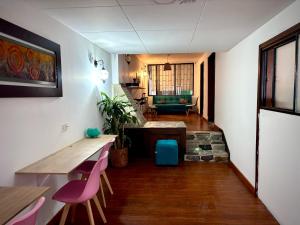 a living room with a table and pink chairs at Yachi Hostel et Kuyay in Bogotá