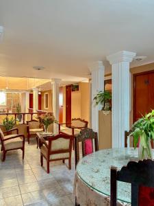 a lobby with tables and chairs and columns at Hospedaje Anais in Pisco