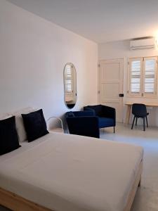 a bedroom with a white bed and a blue couch at Guesthouse Cacau e Café in Santo António