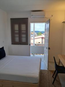a bedroom with a bed and a window and a desk at Guesthouse Cacau e Café in Santo António +26 photos
