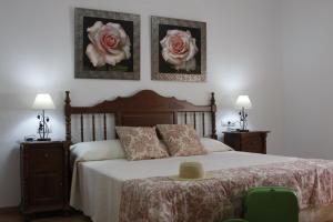 1 dormitorio con 1 cama con 2 rosas en la pared en Casa Rural Galatea especial Grupos, en Ossa de Montiel