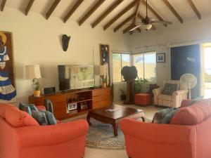 un soggiorno con 2 sedie e una TV di Sikse 3BR 4bath with pool villa a Scarborough