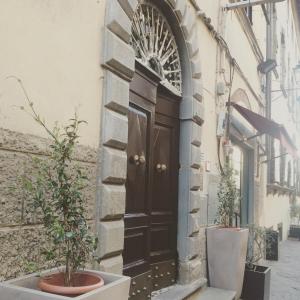 uma porta de madeira ao lado de um edifício com vasos de plantas em La Stagione dell'Arte Luxe em Camaiore
