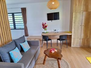 a living room with a couch and a table at Papeari sea side 2 Logement neuf en bord de mer in Paui