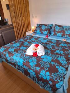 a bed with two stuffed animals on top of it at Papeari sea side 2 Logement neuf en bord de mer in Paui