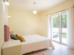 ein Schlafzimmer mit einem Bett und einem großen Fenster in der Unterkunft Casa Aromas do Mar, Burgau in Burgau + 36 Fotos