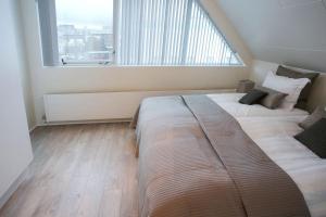 a bedroom with two beds and a large window at Penthouse Downtown with Free Parking in Reykjavík