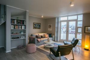 a living room with a couch and a book shelf at Penthouse Downtown with Free Parking in Reykjavík