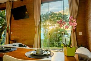 a room with a table and a large window at Cabana nas montanhas em Campos do Jordão in Campos do Jordão
