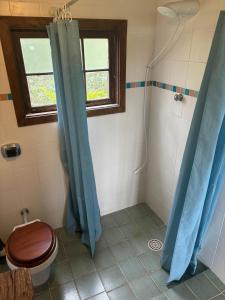 a bathroom with a toilet and a window and a shower at Casa Charmosa ao lado da Villa Mandacaru in Itu