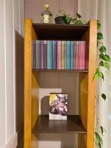 un estante de libros con libros y una foto en él en Rainforest Retreat Home and Waterfall, en Camboriú