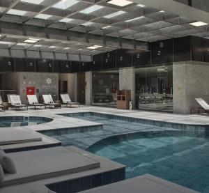 Una gran piscina en un edificio con sillas. en Ap 311 ou 312B Exclusive Gramado, en Gramado