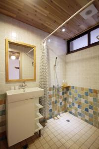 une salle de bain avec un lavabo et une douche dans l'établissement Little Time Guesthouse, à Taïtung