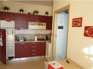 a kitchen with brown cabinets and a table in a room at Nido Dei Gabbiani in Magliolo