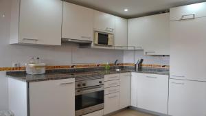 a white kitchen with white cabinets and appliances at Villarcayo Home in Villarcayo +11 photos